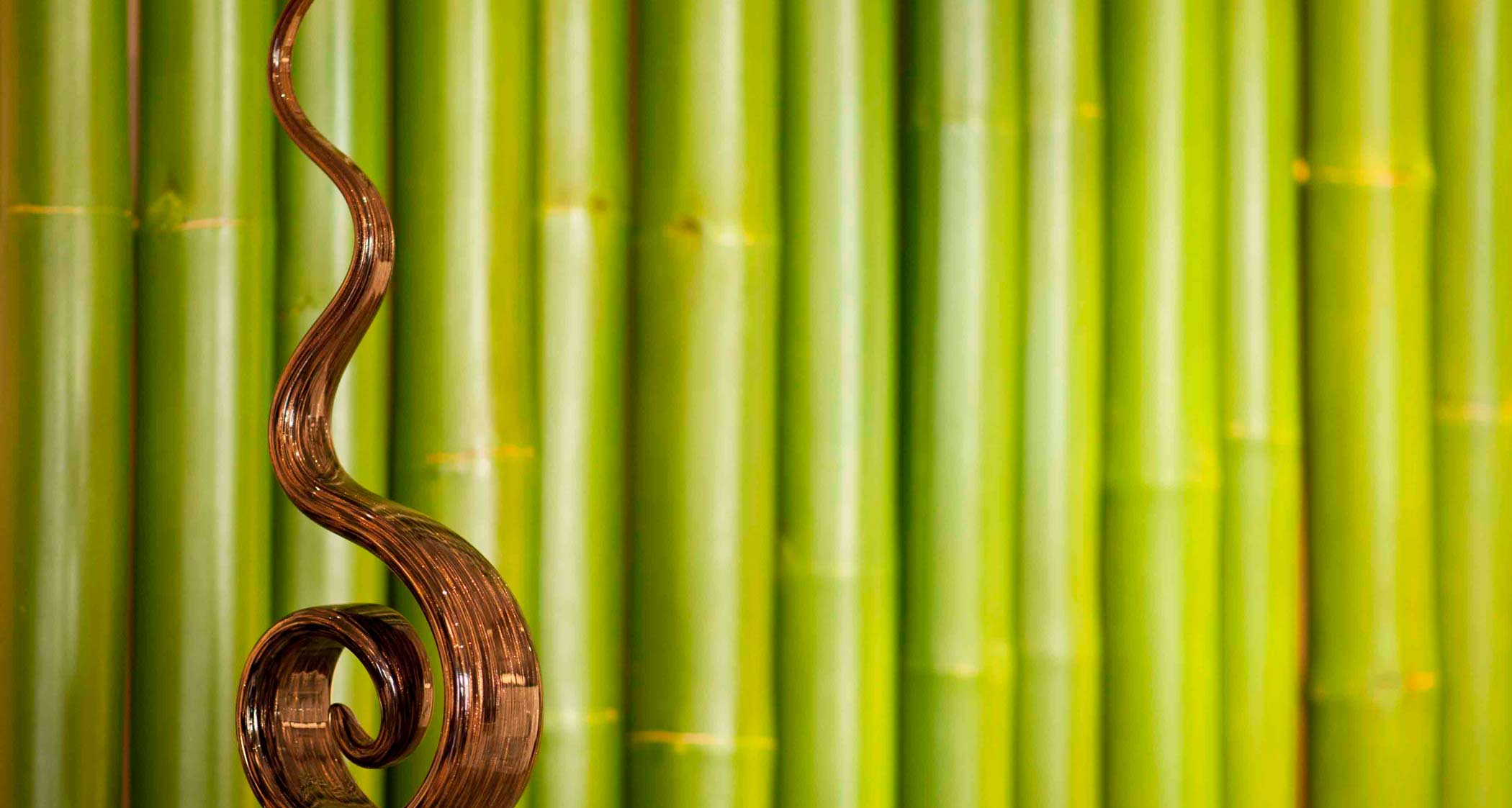 Paravent bambou en bois vert et sculpture en verre représentant une flamme, déco nature et Déco Hôtels.